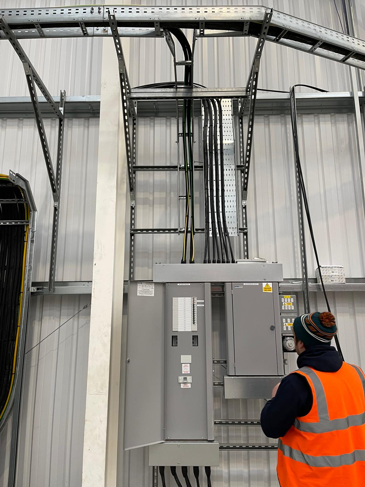 Linehan Electrical engineer working on electrical panels in a new-build warehouse